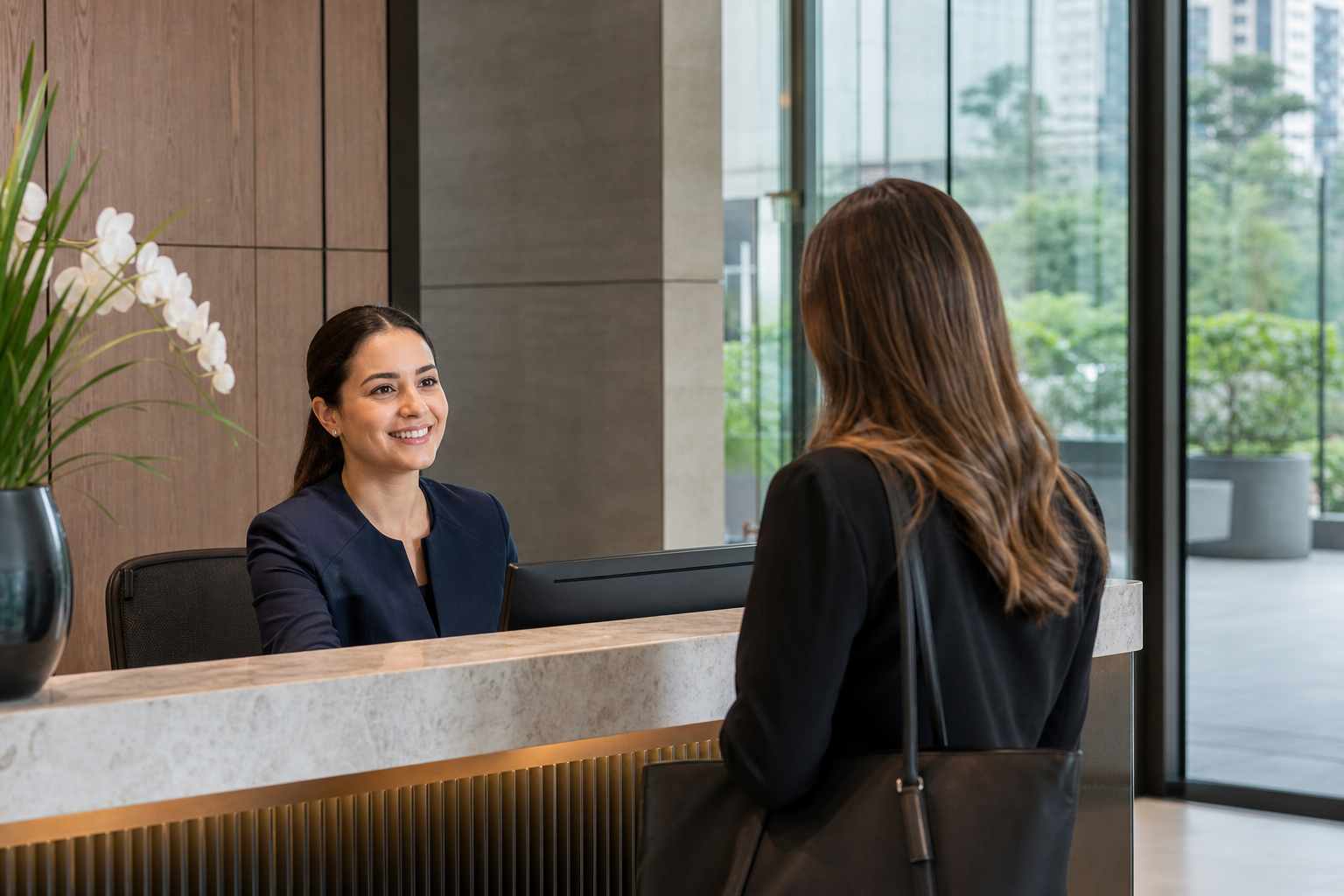 Recepcionista atendendo uma visitante em uma recepção contemporânea